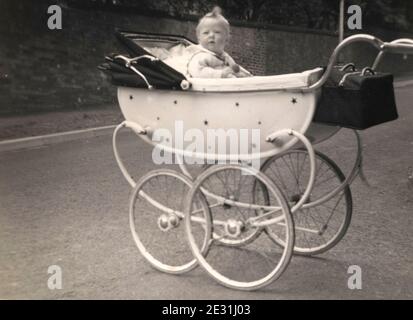 Babymädchen, das im silbernen Kreuz Kinderwagen in Lancashire sitzt, 1960 Stockfoto