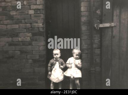 Kinder in armen Reihenhäusern mit Außentoiletten im Großbritannien in den 1960er Jahren Stockfoto