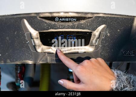 Mädchen Hand Einstellung Temperatur auf Heizung. Zentrale Heizungssteuerung. Einstellungen für die Temperatur des Heizsystems. Bukarest, Rumänien, 2020 Stockfoto