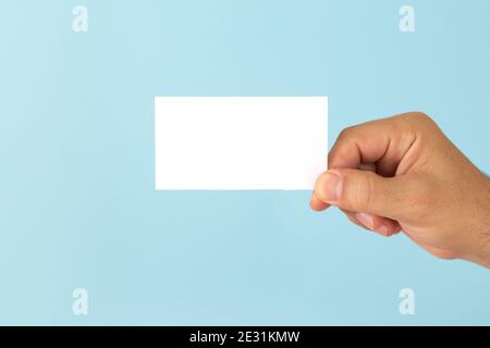 Businessman Hand mit leerer Visitenkarte auf hellblauem Hintergrund. Modell für dein Design Stockfoto