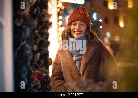 Frau lächelt und schaut in die Kamera auf dem Weihnachtsmarkt Stockfoto