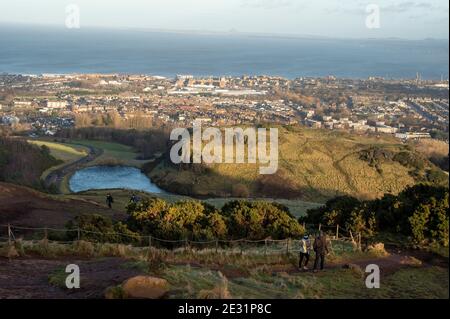 Edinburgh, Schottland, Großbritannien. 16. Januar 2021: Coronavirus tägliche Übung. Die Straßen und Wege im Holyrood Park waren voll mit Menschen, die ihre tägliche Bewegung nahmen. Für diejenigen, die für den Aufstieg, die ganz oben auf Arthur's Seat gab einige tolle Ausblicke über Schottlands Hauptstadt.Quelle: Alamy Live News Stockfoto