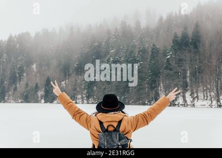 Weibchen spreizen ihre Arme, während sie in der Mitte von steht Ein schneebedeckter Fiel Stockfoto