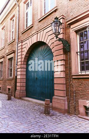 Typische alte Straße in der historischen Düsseldorfer Altstadt: Altes Backsteingebäude am Rhein mit blauer Tür, alte Gaslaterne und Pflastersteinpflaster. Stockfoto