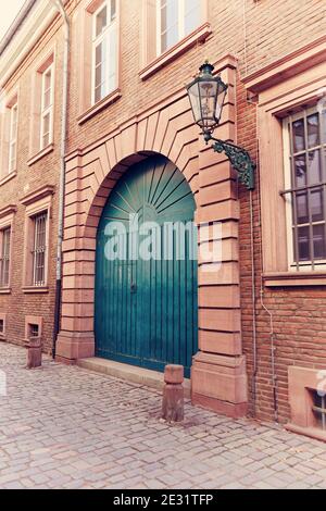 Typische alte Straße in der historischen Düsseldorfer Altstadt: Altes Backsteingebäude am Rhein mit blauer Tür, alte Gaslaterne und Pflastersteinpflaster. Stockfoto