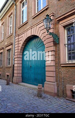 Typische alte Straße in der historischen Düsseldorfer Altstadt: Altes Backsteingebäude am Rhein mit blauer Tür, alte Gaslaterne und Pflastersteinpflaster. Stockfoto