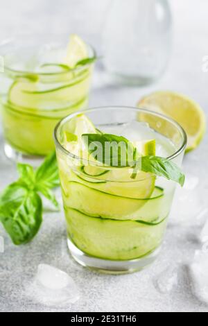 Sommer hausgemachte Limonade aus Limette, Zitrone, Gurke und Basilikum mit Eis im Glas auf einem alten Betonboden. Selektiver Fokus. Stockfoto