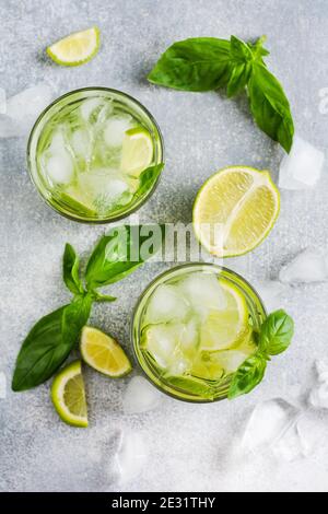 Sommer hausgemachte Limonade aus Limette, Zitrone, Gurke und Basilikum mit Eis im Glas auf einem alten Betonboden. Selektiver Fokus. Stockfoto