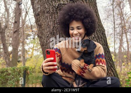 Ein kubanisches Mädchen, das mit ihrem Dackel ein Selfie gemacht hat Der Park Stockfoto