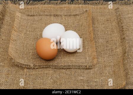 Drei Eier liegen auf dem rohen Sacktuch Stockfoto