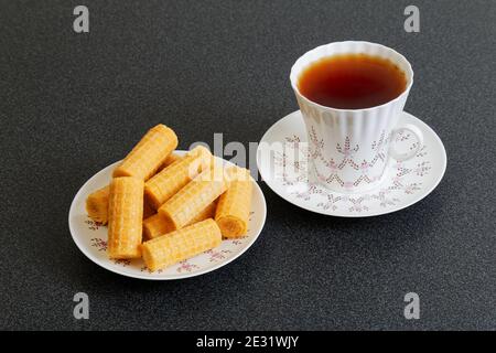Waffer Rollen und Tasse porzellan Tee im Dunkeln Tabelle Stockfoto