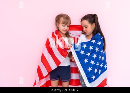 Staunende kleine Kinder Mädchen zeigt weißes T-Shirt, isoliert auf rosa Hintergrund. Lifestyle-Konzept für die Kindheit. Erstellen Sie einen Mock-up-Kopierbereich. Zeigefinger Stockfoto