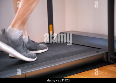 Ein Mann, der zu Hause auf dem Laufband läuft. Bewegungsunschärfe. Nahaufnahme. Stockfoto