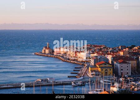 Piran, malerische Altstadt am Meer in Slowenien gegen schneebedeckte alpen Berge im Winter. Stockfoto