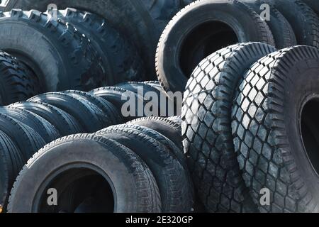 Recycling von Autoreifen für LKW. Das sind viele schwarze Glatzenreifen, die draußen in einem offenen Lager liegen. Stockfoto