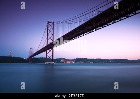 Blick in der Abenddämmerung der Brücke vom 25. April in Lissabon, Portugal. Leerzeichen für Text. Stockfoto