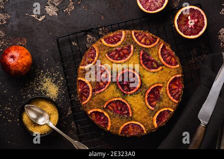 Kopfüber Blut orange Kuchen auf alten dunklen Beton Hintergrund. Rustikaler Stil. Selektiver Fokus Stockfoto