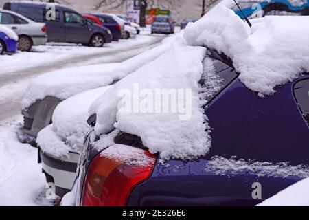 Autos mit einer dicken Schicht gefrorenen Schnees bedeckt. Der Gutsparkplatz im Winter. Stockfoto