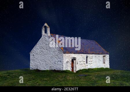 St Cwyfan's ist eine Kirche aus dem 12. Jahrhundert auf der Gezeiteninsel Cribinau, Anglesey. In diesem Fantasy-Bild wurde der Nachthimmel hinzugefügt. Stockfoto