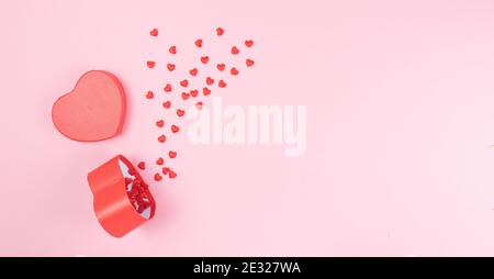 Valentinstag Grußkarte Vorlage. Rosa Hintergrund mit kleinen roten Herzen kommen aus dem herzförmigen Geschenk-Paket. Speicherplatz kopieren. Flach auflegen, oben w Stockfoto