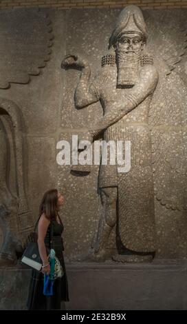 Frau betrachtet ein assyrisches Relief im British Museum, London, England, Großbritannien Stockfoto