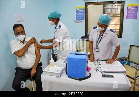 Eine Krankenschwester hat gesehen, wie sie ein medizinisches Pflegepersonal im Rajawadi Krankenhaus impfen konnte.das landesweite Impfprogramm Covid-19 begann heute in Indien. Gesundheitshelfer vor Ort sind die erste Gruppe von Menschen, die geimpft werden. Stockfoto