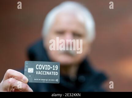 Älterer Mann mit einem Impfpass, der auf eine Impfung gegen covid-19 hinweist. Stockfoto