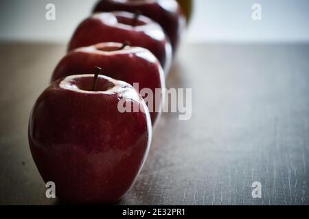 Mehrere rote helle Äpfel in einer Reihe. Nahaufnahme von roten Äpfeln. Stockfoto