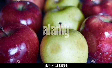 Mehrere leuchtend rote Äpfel und grüne Äpfel. Nahaufnahme von roten und grünen Äpfeln. Rote und grüne Äpfel in einer Reihe. Stockfoto