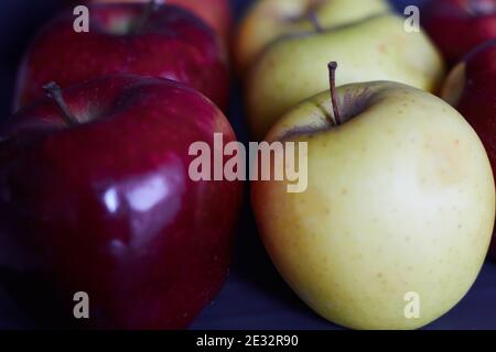 Mehrere leuchtend rote Äpfel und grüne Äpfel. Nahaufnahme von roten und grünen Äpfeln. Rote und grüne Äpfel in einer Reihe. Stockfoto