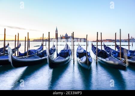 Venezianische Gondel bei Sonnenaufgang, Gondeln in Venedig mit San Giorgio Kloster im Hintergrund, Italien Stockfoto