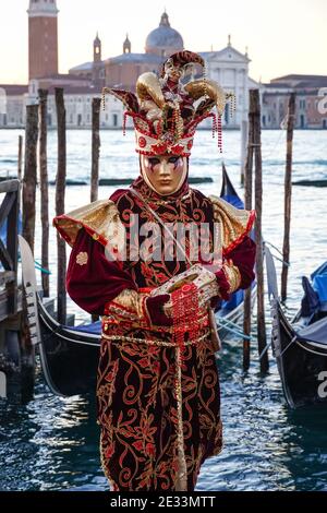 Menschen, die während des Karnevals in Venedig, Italien, in traditionell dekorierten Kostümen und bemalten Masken gekleidet waren Stockfoto