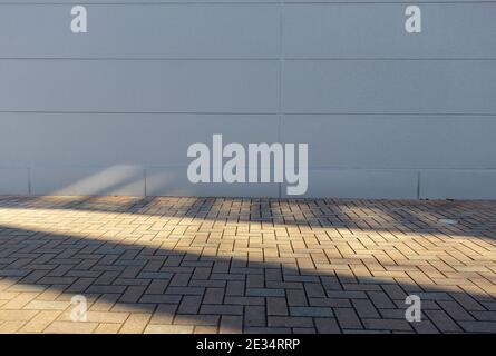 Schatten einer Treppe, auf Steine und eine weiße Wand gegossen. Stockfoto