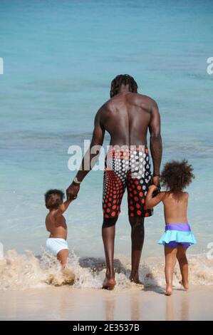 Vater und ein junger Sohn und Tochter gehen auf dem Strand zum Meer zum Schwimmen Stockfoto