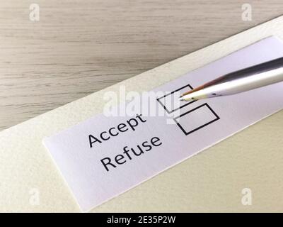 Eine Person beantwortet die Frage auf einem Blatt Papier. Die Person denkt zu akzeptieren oder abzulehnen. Stockfoto