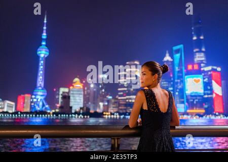 Shanghai City Nachtlichter leuchten in dunklem Himmel. Elegante Dame am Bund Fluss in ausgefallenen Spitzenkleid Abendkleid. Asiatische Modellbesichtigung. Stockfoto