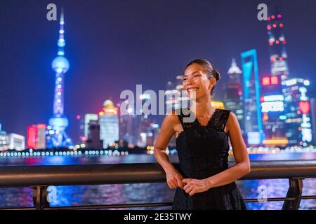 Elegante asiatische Frau lächelnd genießen Nachtclub gehen in Schwarze Mode Kleid am Bund Fluss in Shanghai Ansicht Der Lichter der Stadt Pudong Skyline Stockfoto