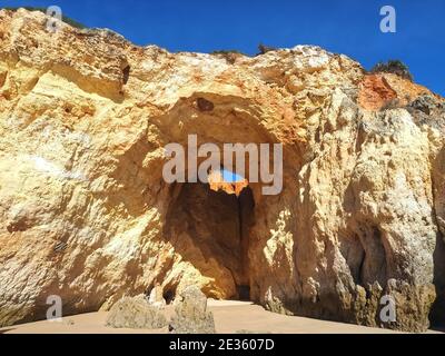 Praia da Vau mit einer Höhle mit einem Loch in den blauen Himmel in Portimao, algarve Küste, Portugal Stockfoto