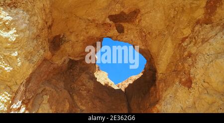 Praia da Vau mit einer Höhle mit einem Loch in den blauen Himmel in Portimao, algarve Küste, Portugal Stockfoto