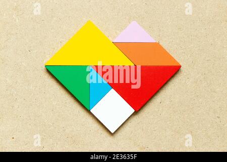 Farbe Tangram Puzzle in Herzform auf Holz Hintergrund Stockfoto