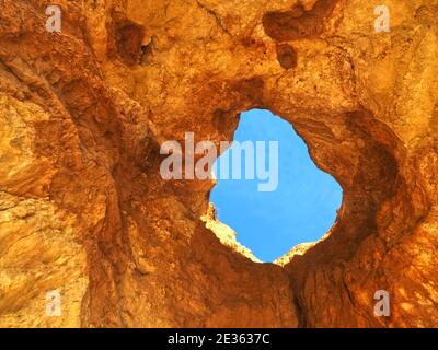 Praia da Vau mit einer Höhle mit einem Loch in den blauen Himmel in Portimao, algarve Küste, Portugal Stockfoto