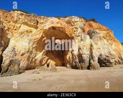 Praia da Vau mit einer Höhle mit einem Loch in den blauen Himmel in Portimao, algarve Küste, Portugal Stockfoto