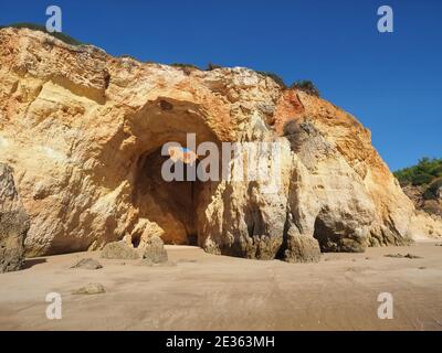 Praia da Vau mit einer Höhle mit einem Loch in den blauen Himmel in Portimao, algarve Küste, Portugal Stockfoto