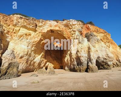 Praia da Vau mit einer Höhle mit einem Loch in den blauen Himmel in Portimao, algarve Küste, Portugal Stockfoto