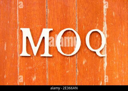 Buchstabe im Wort MOQ (Abkürzung für Mindestbestellmenge) Auf alten roten Farbe Holzplatte Hintergrund Stockfoto
