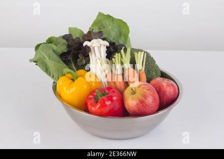 Gemüse und Obst in Edelstahlschüssel isoliert auf weiß Hintergrund Stockfoto