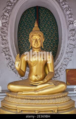 Buddha-Statue, die Buddha mit der Mudra darstellt (Geste) abhaya (Furchtlosigkeit), in Phra Pathum Chedi, einer großen buddhistischen Stupa in Nakhon Pathom, Thailand Stockfoto