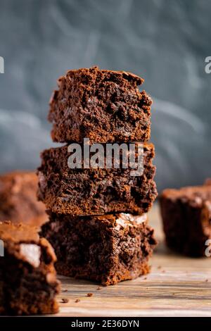 Stapel von drei dicken Brownies auf einem Holzbrett, Lebensmittel Stockfoto