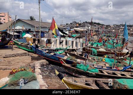 Ghana-Fischerflottendorf an der Kapküste. Westafrika, Atlantischer Ozean. Traditionelle Fischereiflotte handgefertigte Holzboote, farbenfrohe Farbe. Netze und Fanggeräte. Stockfoto