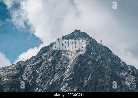 Blick auf den Lomnicky Stit Gipfel, berühmten felsigen Gipfel in der Hohen Tatra, Slowakei. Wolkiger windiger Tag. Stockfoto